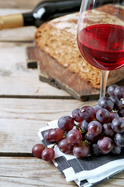 Stilleven van wijn en brood op rustieke houten achtergrond — Stockfoto