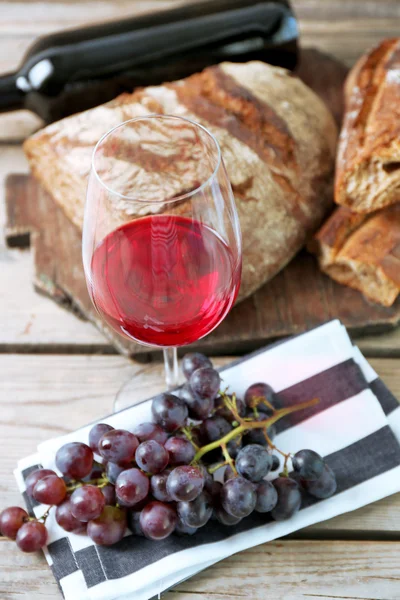 Stillleben von Wein und Brot auf rustikalem Holzgrund — Stockfoto