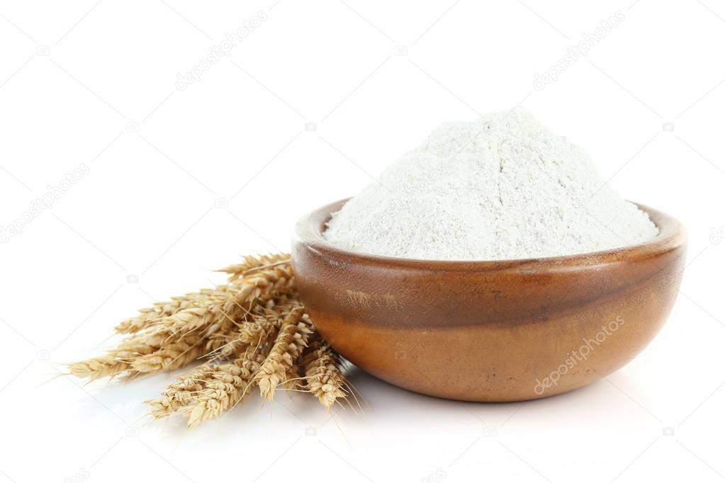 Wheat flour in wooden bowl isolated on white