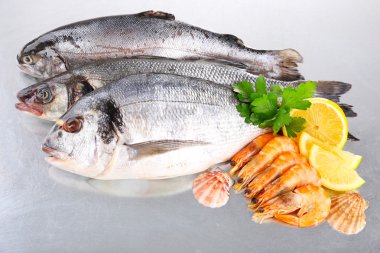 Taze balıklar ve karides ile metal zemin üzerine baharat