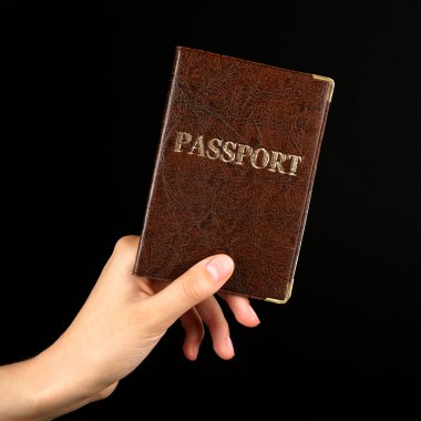 Pasaport koyu arka plan üzerinde tutan el