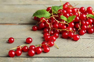 Ahşap arka plan üzerinde olgun kırmızı kuş üzümü