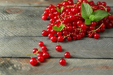 Ahşap arka plan üzerinde olgun kırmızı kuş üzümü