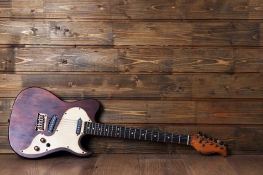 Tahta arka planda elektro gitar