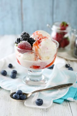 Lezzetli dondurma taze Dondurulmuş çilek ve renk ahşap zemin üzerine sos ile