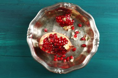 İçinde metal tepsi ahşap masa, üstten görünüm üzerinde sulu nar