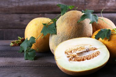 Ahşap zemin üzerine yeşil yaprakları ile olgun kavun