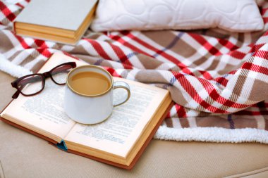 Oturma odasında kanepede kitap ile kahve
