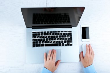 Beyaz masa üstünde laptop ile ofiste çalışan eller