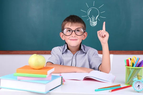 Schoolboy near blackboard with idea bulb — Stock Photo, Image