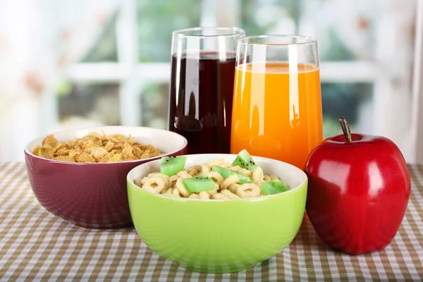 Cereais deliciosos e saudáveis em tigelas com suco e frutas na mesa no quarto — Fotografia de Stock