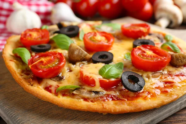 Ízletes pizza zöldségekkel és a bazsalikom a táblázat közelről — Stock Fotó