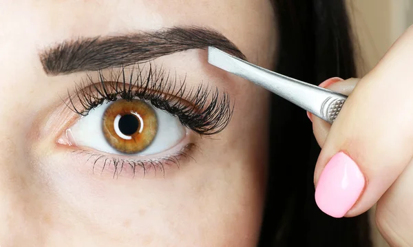 Mujer joven arrancando cejas — Foto de Stock