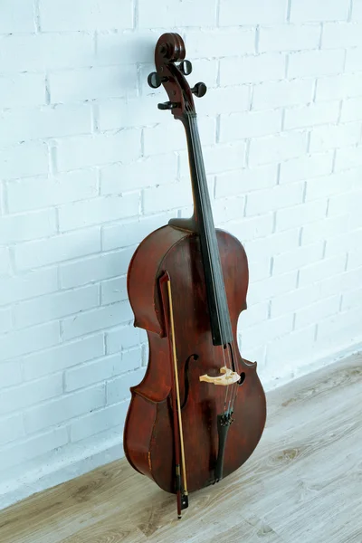 Cello on white brick wall — Stock Photo, Image