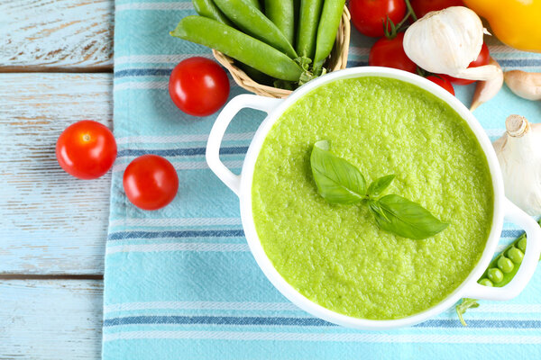 Tasty peas soup and vegetables on table close up