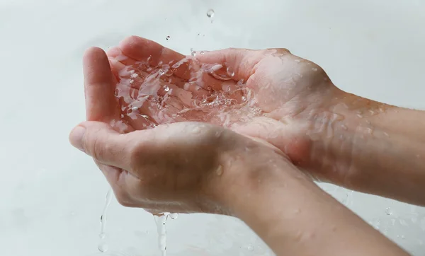 Mains féminines sur l'eau claire — Photo