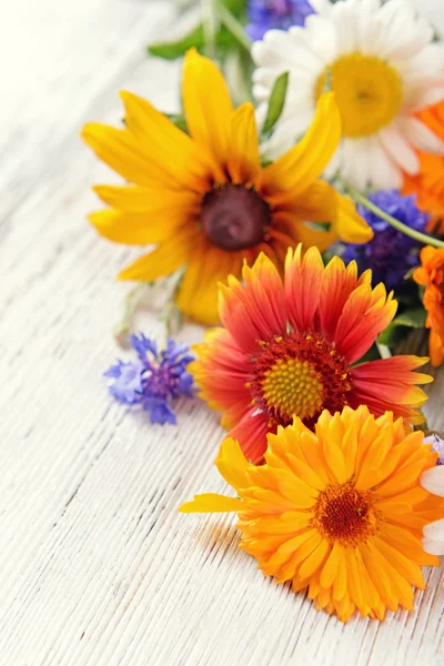 Bright wildflowers on wooden table, closeup — Stock Photo, Image