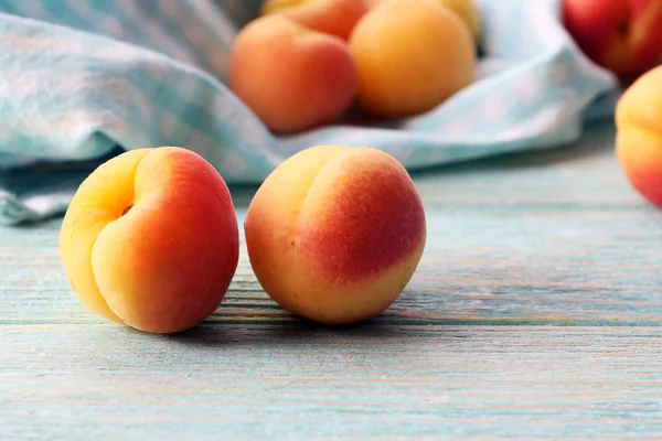 Ripe apricots with napkin on wooden table close up — Stock Photo, Image