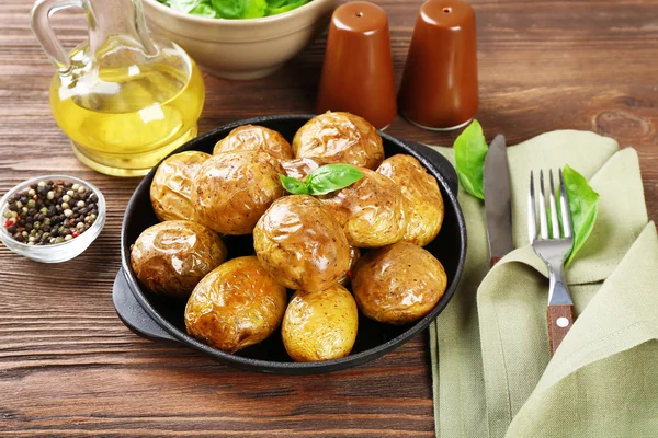 Pečené brambory na pánvi na dřevěný stůl, detail — Stock fotografie