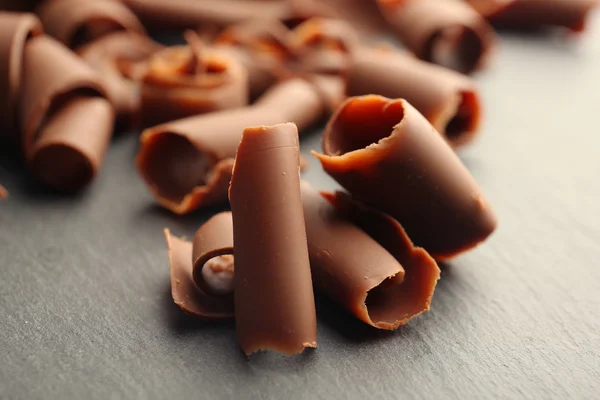 Chocolate curls on wooden table close up — Stock Photo, Image