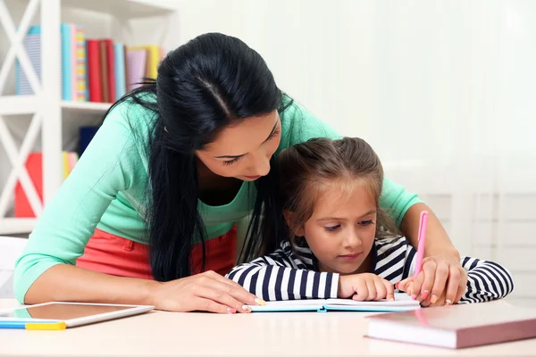 Шкільна дівчина робить домашнє завдання з мамою — стокове фото