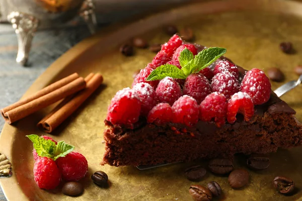 Kuchenstück mit Schokoglasur und Himbeeren auf Blech, Nahaufnahme — Stockfoto