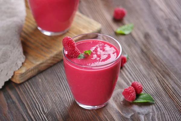 Glasses of raspberry milk shake with berries on wooden table close up — Stock Photo, Image