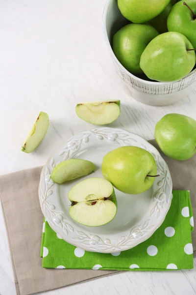 Gröna äpplen i tallriken på bordet med Servett, närbild — Stockfoto