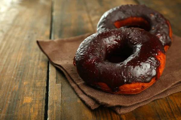 Deliciosas rosquillas con glaseado de chocolate en la mesa de cerca — Foto de Stock