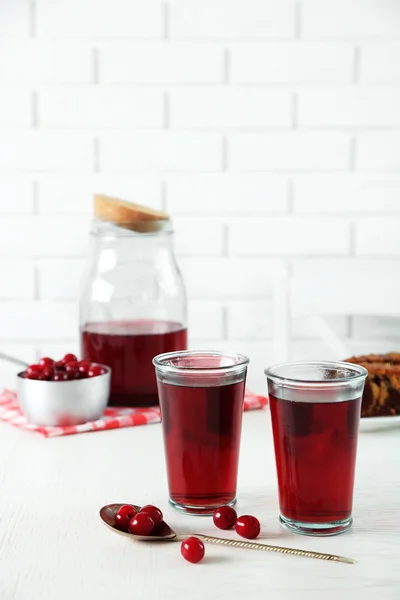 Dwie szklanki z sok wiśniowy na stole, na jasnym tle — Zdjęcie stockowe