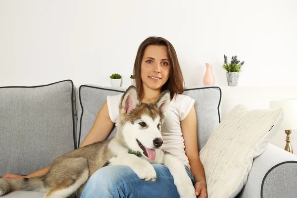 Mulher com seu cão malamute em casa — Fotografia de Stock