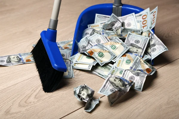 Broom sweeps dollars in garbage scoop — Stock Photo, Image