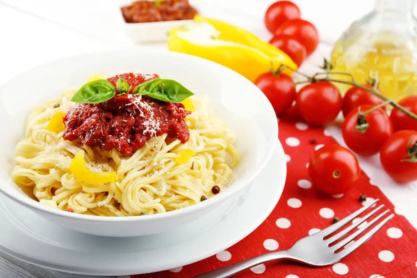 Spaghete cu sos de roșii și brânză pe placă albă, pe fundal de lemn color — Fotografie, imagine de stoc