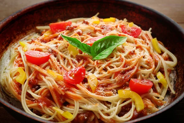 Spaghetti fatti in casa alla bolognese su tegame, su fondo di legno — Foto Stock