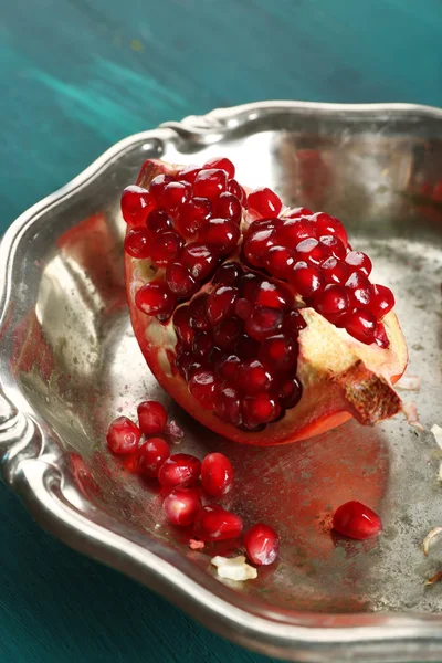 Juicy pomegranate in metal tray on wooden table, closeup — Stock Photo, Image