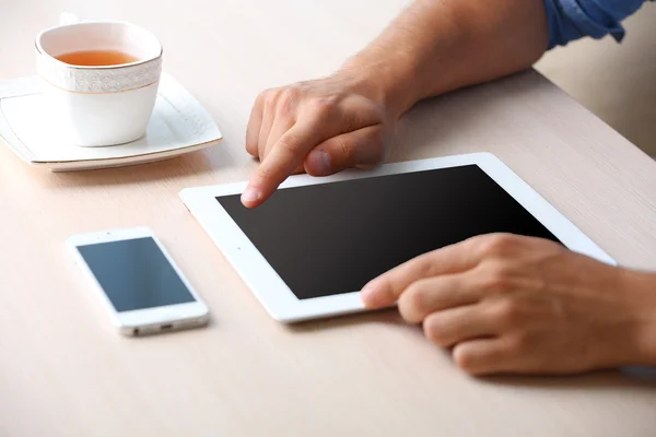 Homme avec tablette numérique sur fond de table en bois — Photo