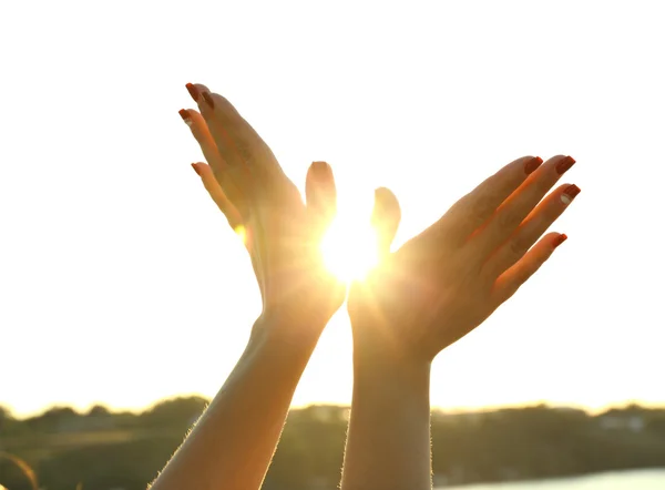 Frauenhände und sonniger Himmel — Stockfoto