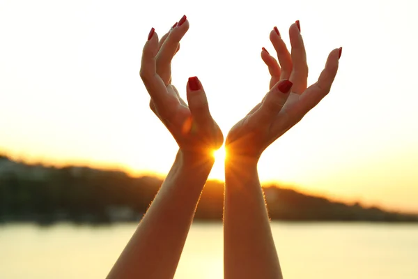 Mãos femininas e céu ensolarado — Fotografia de Stock