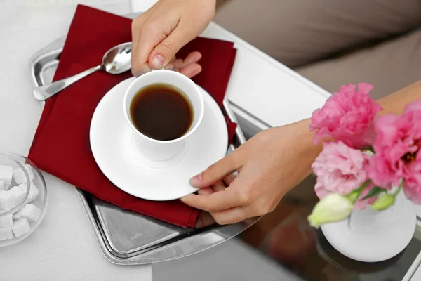 Vrouwelijke hand bedrijf kopje thee op tafel close-up — Stockfoto