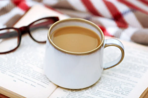 Cup of coffee with book on sofa in living room — Stock Photo, Image