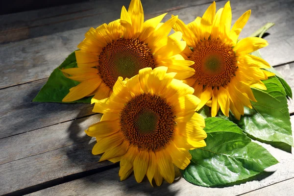 Hermosos girasoles brillantes en la mesa de madera de cerca —  Fotos de Stock