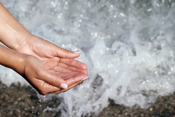 Mano delle donne toccare l'acqua blu . — Foto Stock