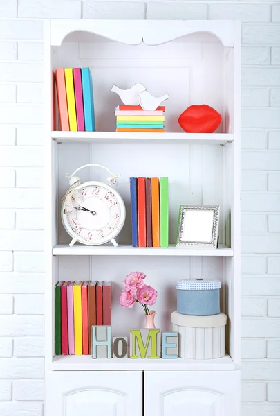 Books and decor on shelves in cupboard