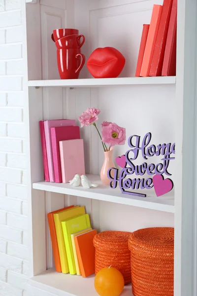 Livros e decoração em prateleiras no armário — Fotografia de Stock