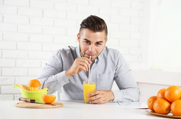 Jovem bebendo suco de laranja — Fotografia de Stock