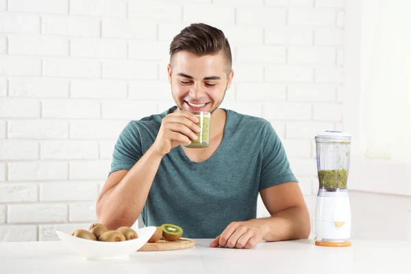 Junger Mann trinkt frischen Kiwi-Saft — Stockfoto