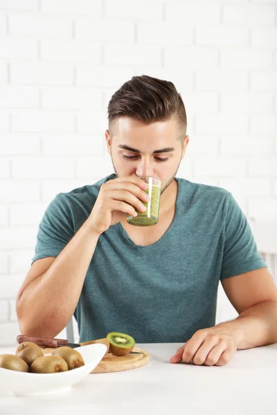 Young man drinking fresh kiwi juice — Stock Photo, Image