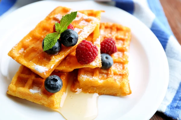 Süße hausgemachte Waffeln mit Waldbeeren und Soße auf Tischhintergrund — Stockfoto