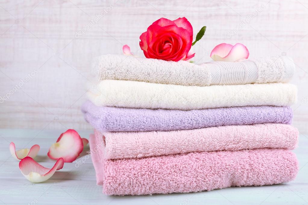 Stack of colorful towels on light wooden background