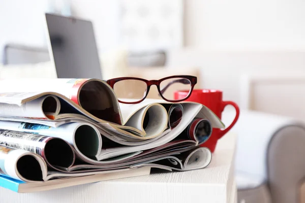 Magazines and laptop on table in living room, close up — Stock Photo, Image